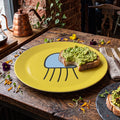 Yellow Poly jellyfish plate with avocado toast on a rustic cafe table.