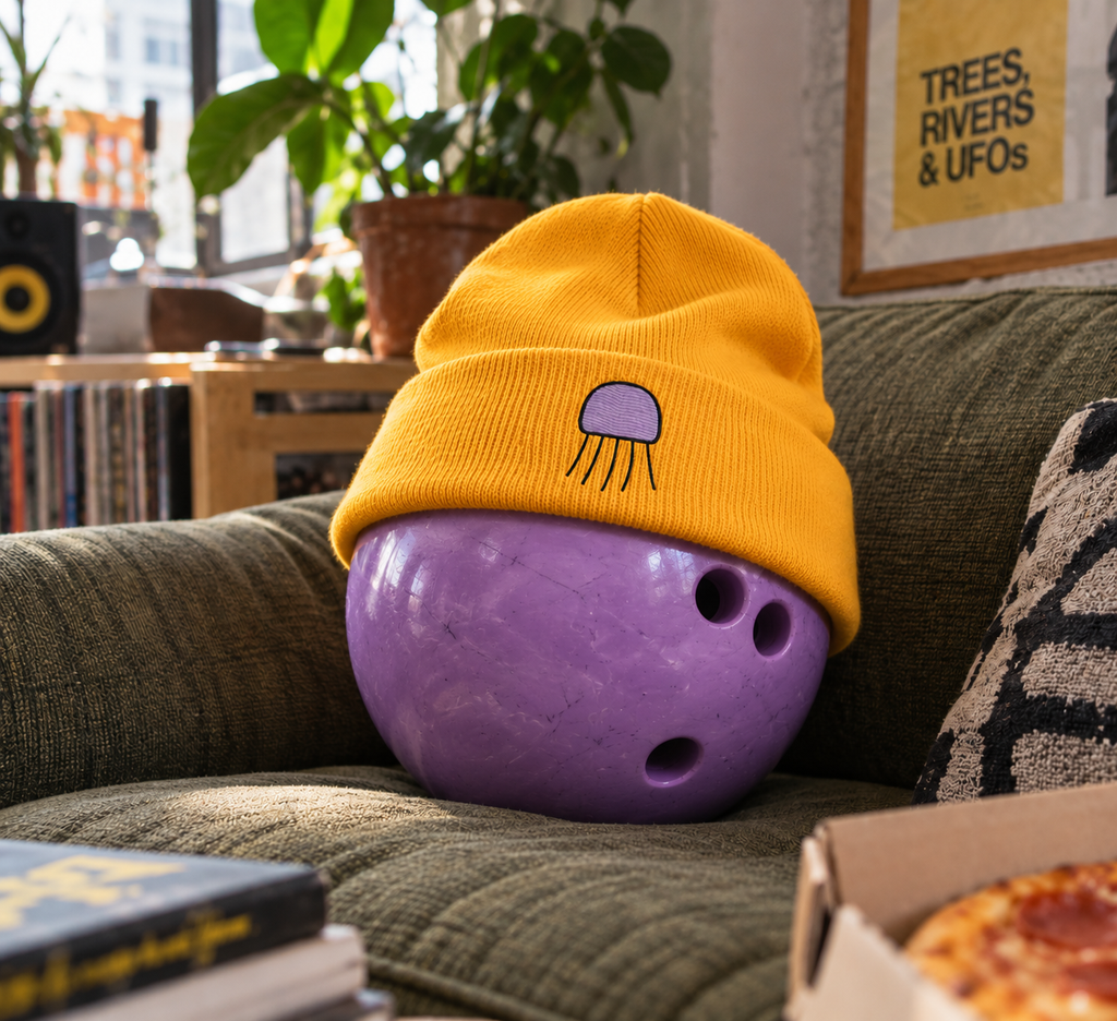 Gold Orchid Beanie with purple Jellyfish embroidery on a purple bowling ball