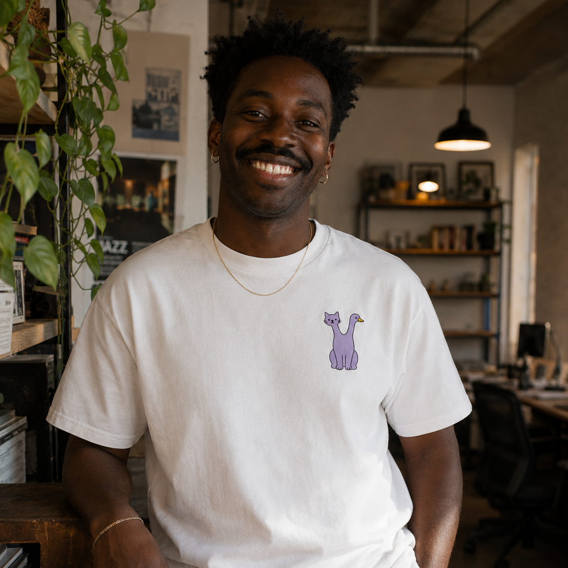 Man wearing the white Trees, Rivers & UFOs Quackcat Tee featuring purple cat and duck embroidered FrankenFarm artwork.