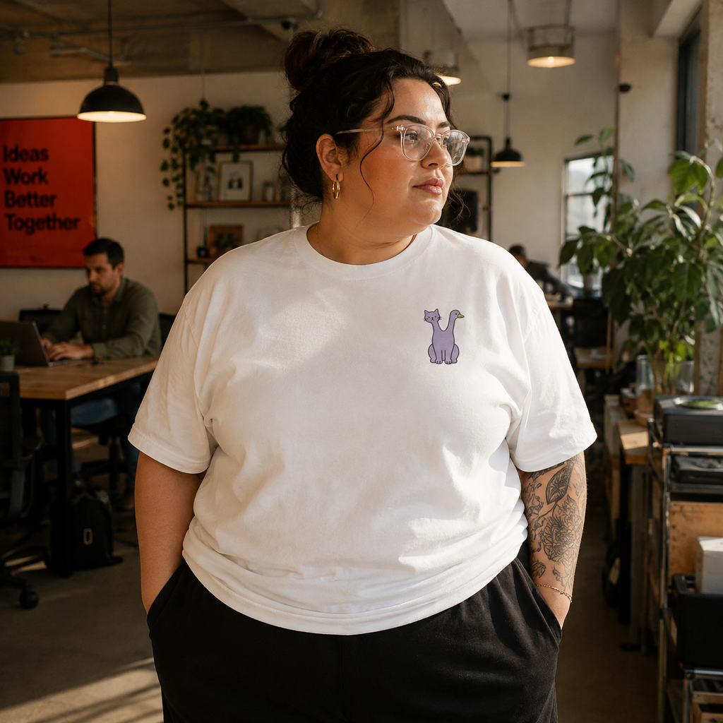Woman wearing the white Trees, Rivers & UFOs Quackcat Tee with purple two-headed cat and duck embroidered FrankenFarm artwork.