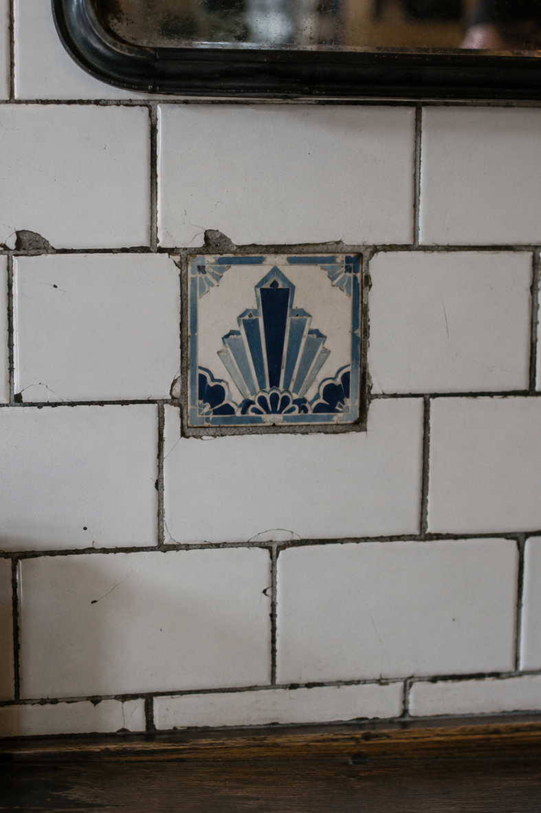 A mismatched replacement tile interrupting an Art Deco pattern.