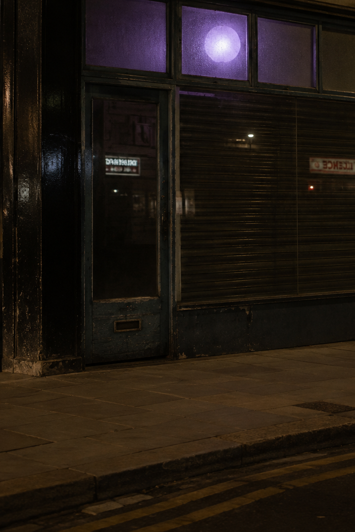 Purple light glowing inside a laundrette at night.