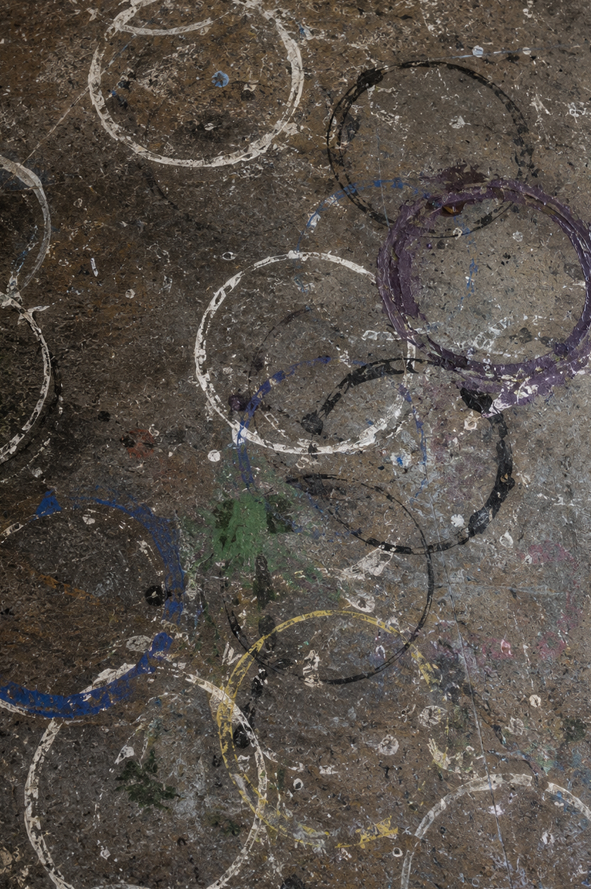 Circular paint marks layered across a studio floor.